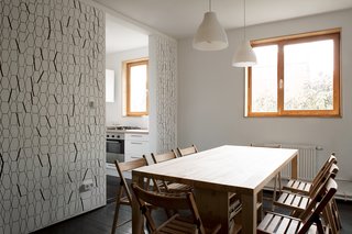 A Compact Home in Moscow Built on the Lowest Possible Budget - Photo 5 of 9 - Chairs and lights from IKEA accompany a custom dining table, which incorporates shelving and storage space underneath.