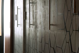 A Compact Home in Moscow Built on the Lowest Possible Budget - Photo 6 of 9 - Like the nearby dining room wall, this custom-made wood storage space was painted white then enhanced with a geometric pattern, drawn on with black felt-tip pens. Cabinet handles from Leroy Merlin complement the graphic design.
