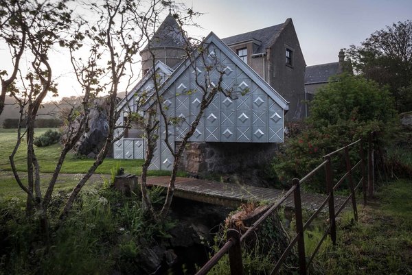 While making its own unique mark, the studio is also deeply respectful towards its historic surroundings. The structure sits directly on top of a Victorian "midden wall," an enclosure traditionally used by the adjacent stables as a depository for horse manure. The studio's twin gables mimic its direct neighbors, and the zinc molding on the gutter also echoes its Victorian predecessors. Photo 7 of Midden Studio modern home