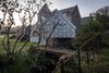 While making its own unique mark, the studio is also deeply respectful towards its historic surroundings. The structure sits directly on top of a Victorian "midden wall," an enclosure traditionally used by the adjacent stables as a depository for horse manure. The studio's twin gables mimic its direct neighbors, and the zinc molding on the gutter also echoes its Victorian predecessors. Photo 7 of Midden Studio modern home