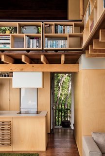 Architect and resident Andrew Simpson maximized the diminutive home with double-height ceilings, elevated compact shelving, and lofted sleeping quarters.