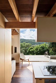 The home also extends into outdoor panoramas, even—and especially—from the ground floor, where a westward-facing deck cantilevers out into the lush landscape.