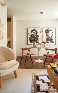 This Luxurious Apartment in Greenwich Village Is Only 520 Square Feet - Photo 5 of 6 - Dufner organized the studio by using furniture and rugs to divide it into zones for different functions. In the dining area, the floor is fumed oak—a technique that incorporates the use of ammonia to deepen the wood’s color and bring out the grain. A pair of Grass-Seated chairs by Nakashima Studio surround a Tulip table by Eero Saarinen for Knoll.