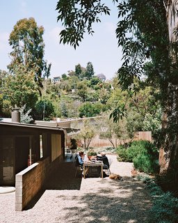The couple asked Bryan Richards of Real Natives Landscape Design to incorporate drought-tolerant plants into the landscaping. Surrounding a table from CB2 are chairs from Design Within Reach.