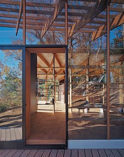 Japanese Home Among the Trees Uses Bookshelves and Glass for Walls - Photo 6 of 8 - See-through dividers in the form of open bookshelves define the interior public spaces; the fiberboard planks are by Hokushin.