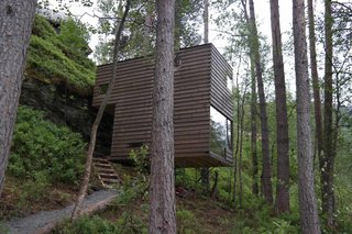 11 Hillside Homes That Feature a Balancing Act With Nature - Photo 10 of 10 - The cabins by Jensen & Skodvin Architects are built on a steep hillside. They're held aloft by narrow steel rods and clad in a lumber that's stained to blend into the natural surroundings.