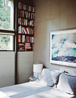 In the master bedroom, above the Legnoletto by Alias bed, is a photograph by John Huggins. The lamp is from Ikea. "Nothing is painted—all that stripping is about getting to the natural surfaces of the wood, and the concrete block," Norelius says.