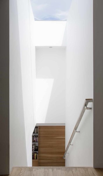 A new operable skylight above the stairs offers an alluring visual connection to the outdoors, while providing passive climate control. On cool days, light floods the space from above and warms the home, while on warmer days, the open skylight allows air to circulate. The skylight is one of the owners’ favorite part of the home—seeing the changing light through the opening, catching glimpses of the moon at night, or listening to the rain on its surface. Photo 7 of KS Mission modern home