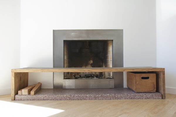 Though the home had obvious midcentury charm when they found it, some of the period details were masked by architecturally incongruent additions over the years, including crown molding and a traditional fireplace mantel, details that seemed out of place within the context of the modern redesign. Through the renovation, the molding was taken down, as was the cast plaster mantle. The sleek new fireplace features a white oak custom bench made by Zack, accented by a vintage carnation milk crate from his mother’s childhood. Photo 9 of KS Mission modern home