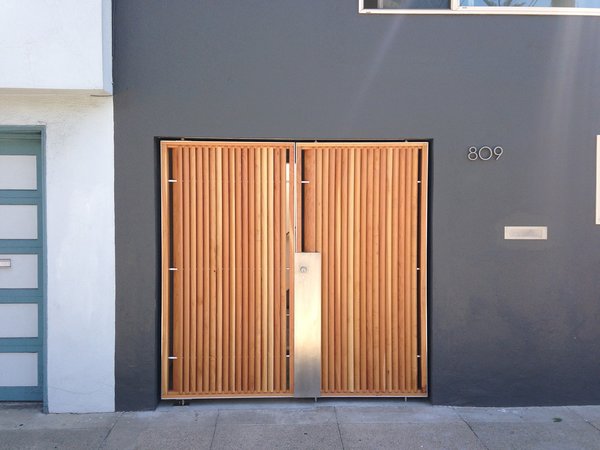 The focal point of the home’s modernized exterior is a custom wood-and-steel entry gate designed by atelier KS and built by DeFauw Design + Fabrication, a local fabricator who also made custom closing hardware for the piece. Franz and Paré-Mayer paired angled cypress slats with an industrial metal frame to create the entryway. A few paces behind the gate, a large glass door provides direct access to the home, fulfilling the owners’ wish for an entry vestibule that would be separate from the street. The angled wood slats offer privacy from the exterior, while selectively allowing light to penetrate through. Photo 10 of KS Mission modern home
