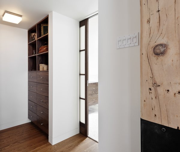 The architects had to master the art of hiding storage throughout the apartment, including with this custom walnut organizer. As the homeowners near retirement age, the architects explain that the flat is a “highly functional and sophisticated space that will serve them well as they begin another phase in their life together.” Photo 7 of Brick House modern home