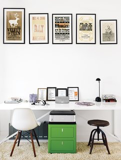 1920s Bungalow Plus Modern Addition Equals Perfect Austin Home - Photo 6 of 11 - In the office, which is part of the addition, a collection of vintage posters hangs above a Cbox file cabinet and a table from Blu Dot used as a desk. The rug is a Photon.