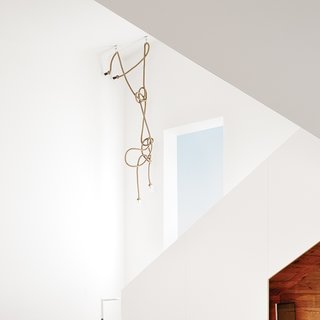 1920s Bungalow Plus Modern Addition Equals Perfect Austin Home - Photo 9 of 11 - The stairway chandelier is made from designer Christien Meindertsma’s flax-rope lamps for Thomas Eyck, which feature the same material as those used in Dutch shipping yards. At eight months pregnant, in anticipation of the new baby, Suttles mounted a ladder to arrange the rope, which her stepmother strategically sewed to achieve just the right shape.