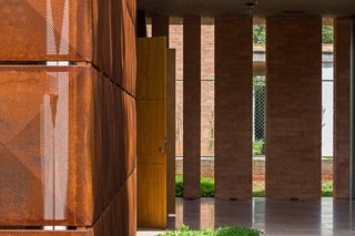 This Cor-Ten House in Brazil Would Not Be Complete Without its Giant Home Library - Photo 6 of 7 - The same materials palette continues throughout the entire home. A cohesive marriage of Cor-Ten steel, handcrafted bricks, and marble floors come together at the home’s perimeter. The thick exterior walls were designed to act as an insulating barrier, shielding interior spaces against thermal loss.