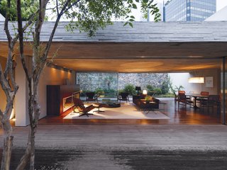 Following the birth of their second daughter, Reinaldo and Piti Cóser knew they needed a bigger home that could provide domestic refuge from the relentless energy of São Paulo without separating them from it completely. After purchasing a site in the centrally located Jardim Europa neighborhood, they turned to architect and close friend Marcio Kogan to help them accomplish their dream. The resulting structure features a garden that is separated from the living room by only a sliding door, creating one large mixed-use living space. While this gives the home a feeling of tranquility, the rooftop deck yields intimate views of the city, reminding viewers of its nearby influence.
