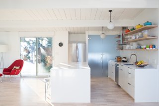 Sunny Renovation of an Eichler Great Room - Photo 3 of 5 - All the floors were redone in a light ash hardwood. The crisp interior paint is Benjamin Moore Super White. The kitchen cabinets are from Artistic Kitchens. A frosted glass door leads to the laundry room.