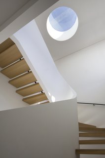 5 Architectural Tricks and Devices to Bring Natural Light Into Your Home - Photo 6 of 12 - A small circular skylight provides natural light at the top of this sculptural staircase.