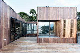 An Australian Beach Home with Stunning Ocean Views - Photo 1 of 8 - Operable timber shutters and screens offer protection from extreme weather. Zoning the house into three distinct masses creates a partly sheltered courtyard to make this year-round blending of the indoors and outdoors possible.