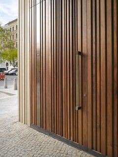 The wooden door mimics the structure's textured exterior.