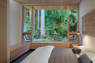"You go down a hall and turn left to go to bed, to block noise from the living room," Jones says. "And each space in the house looks out onto something different, in all directions." The bed is custom-made by Jones, which is covered with linens from Bespoke Design in Victoria, B.C. A black Tolomeo mini table lamp sits on the nightstand.