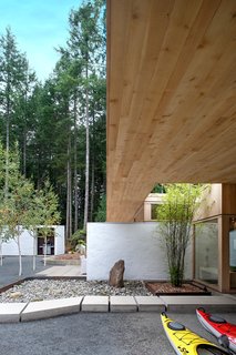 "Their lives revolve around ocean activities, reading, music, and good food and wine," Jones says of the owners. "The new house I designed is just for them," such as with this sheltered outdoor areas where gear can be stored; the ceilings above are also Douglas fir.