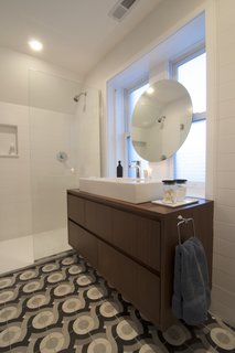 A Chicago Renovation Taps Into its Attic to Almost Double its Square Footage - Photo 8 of 8 - Shively describes himself as "big on graphics" and designed these tiles, produced by Original Mission Tile in San Luis, Mexico, to add his own flair to the master bathroom. A simple floating vanity and minimalist shower let the custom tilework take center stage.
