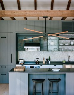 25 Homes With Exposed Beams: Rustic to Modern - Photo 3 of 25 - A custom Stickbulb LED lamp hangs above a kitchen island topped by concrete from Get Real Surfaces. The beams are stained with LifeTime from Valhalla Wood Preservatives, which will oxidize the material over time.