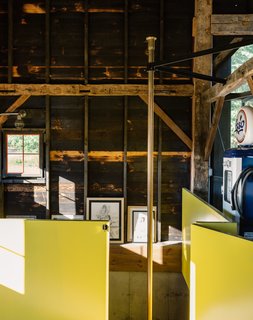 The contractor sourced the brass pole from a fire station in Boston. The surrounding wall is painted in semi-gloss paint in Citrus by Sherwin Williams, a sunny hue the team playfully referred to as Dwell-ow.