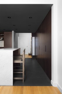 10 Open Kitchen Solutions That Will Get Things Cooking - Photo 2 of 10 - What was formerly a hallway is now integrated with the kitchen. A bank of floor-to-ceiling cabinets offer storage and an island covered in Carrara marble offers space for working or dining. The barstools are from CB2.