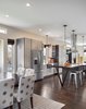 “Because the property is so narrow, we had to be strategic in laying out the plan,” Mitchell says. “Our goal was to create an open plan that spanned from exterior wall to exterior wall in order to make the home feel as large as possible.” Solid oak flooring fills the space and pendants from Kenroy Home illuminate the kitchen. Photo 3 of Highlands House modern home