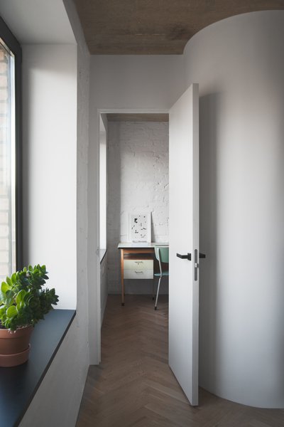 To make the most out of a small footprint, Vorontsov experimented with some creative partitions. He explains how “the partitions we built were straight, and then we rounded the corners slightly in the studio" to create a little extra room. "We left the doors without architraves, and punctuated the detail with black doorknobs.” Photo 6 of Soviet Intelligentsia modern home