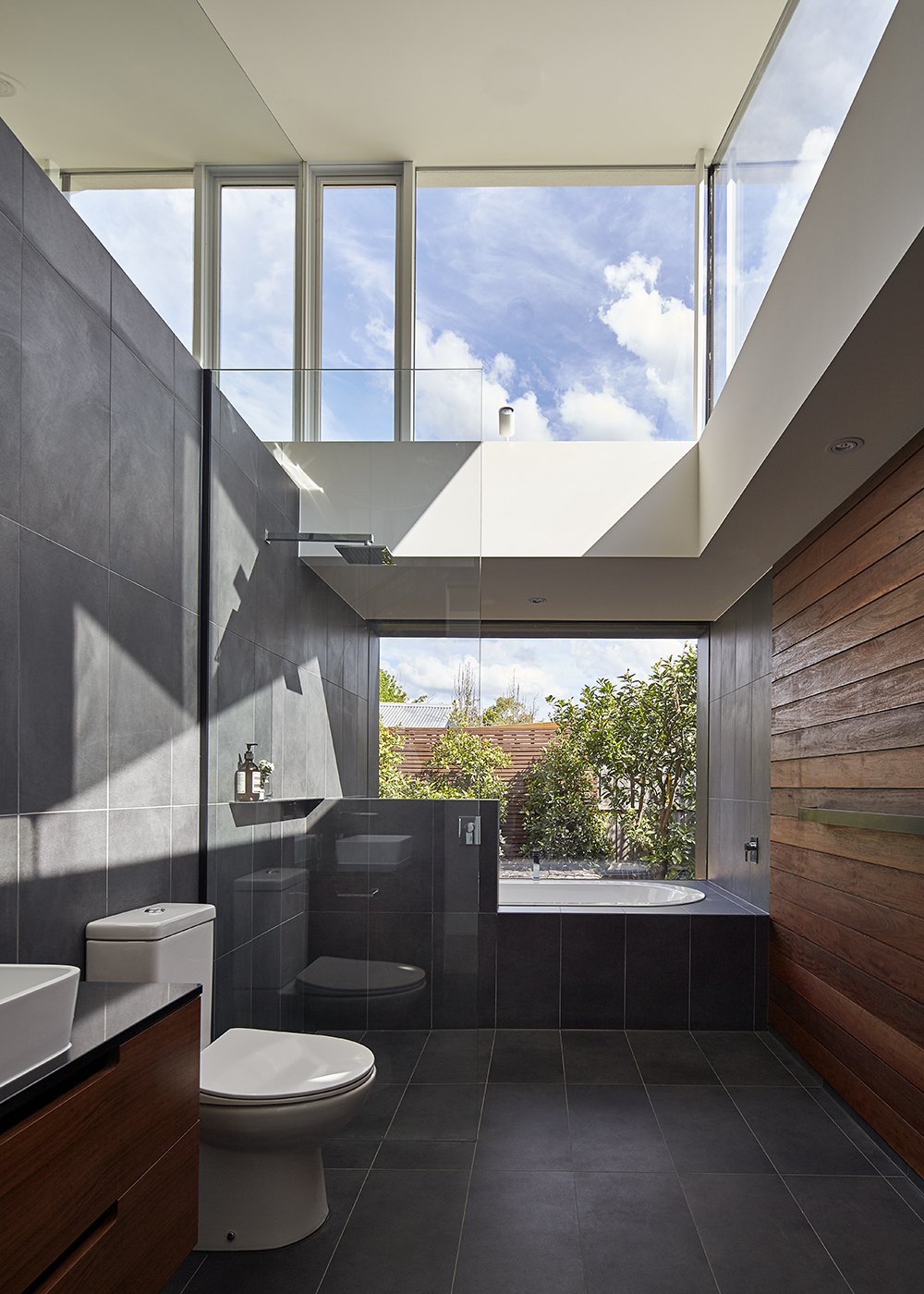 40 Modern Bathtubs That Soak In the View An Envy II Wall-Faced Suite toilet by Parisi sits in the home’s sole bathroom and Caroma’s Starlett 1850 Island Bath was installed next to the window.