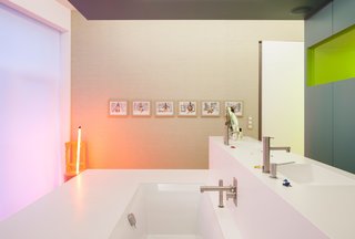 A Creative Dreamworld Complete With Neon Rooms and a Tropical Garden - Photo 7 of 11 - Installed by a local vendor, the Corian sinks and bath combine to form a freestanding island in the upstairs bathroom, outfitted with fixtures by Ritmonio. A series of artworks by Tim, including a sculpture that emits a soft glow, accent the pristine space.