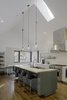 “Knowing that the kitchen would be where the family would spend most of their time, it was designed to have a variety of seating and really good views to the beautiful forest and field outside,” says Lewis. IKEA bar stools line up against white quartz countertops, and lighting by Schoolhouse Electric & Supply Co. shines overhead. Photo 4 of The Farmhouse modern home