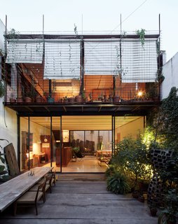 One-of-a-Kind Furniture Fills This Delightfully Serene Buenos Aires Home - Photo 2 of 10 - The patio at the front of the house offers a view of the balcony that connects the second-floor bedrooms.