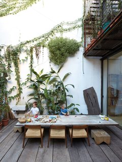 One-of-a-Kind Furniture Fills This Delightfully Serene Buenos Aires Home - Photo 6 of 10 - A custom table surrounded by NET’s Museo chairs and poplar stools provides a space for the Sarmiento Tovo boys, Manuel, 5, and Julián, 3, to play with the toys their mother makes.