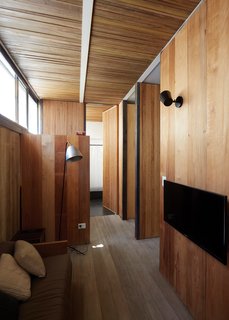 8 Beautiful Home Projects Using Reclaimed Wood - Photo 1 of 8 - Salvaged wood from multiple origins come together in this project in Buenos Aires by architects Teresa Sarmiento and Nicolas Tovo. They designed the home for their own family with the intention of celebrating recycled materials—floor boards of repurposed Brazilian pine and wall boards from the ceiling of a tenement in a local Buenos Aires neighborhood. The boards were cut down to size and oriented vertically to bring the eye upward to a clerestory window and small white beams.
