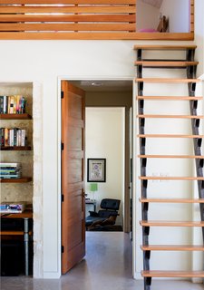 Eames Lounge Chair Porn - Photo 42 of 53 - A custom steel and red oak ship ladder in the main living area is another space-saving solution. The door is Douglas fir and the shelving is mesquite wood; an Eames lounge chair can be seen in the master bedroom.