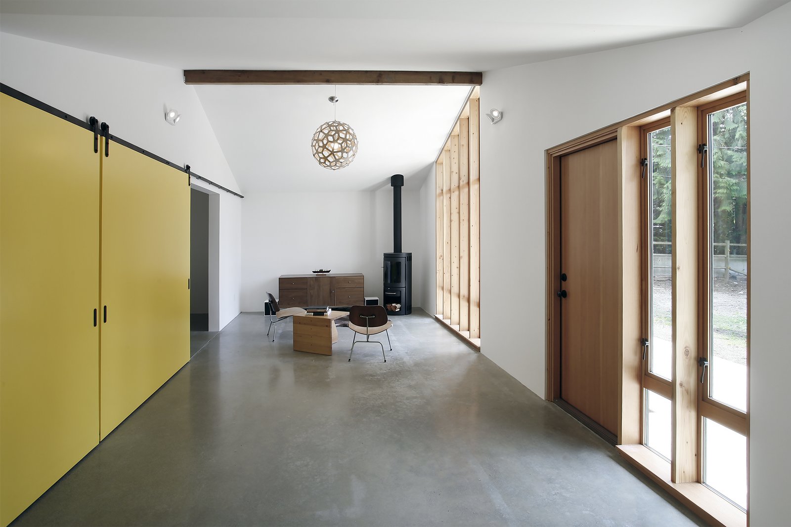The renovated stable's living room is extra bright thanks to walls painted with Benjamin Moore’s Atrium White and reflective polished concrete floors. The latter conceal a radiant heating system.