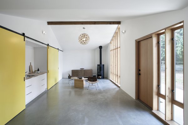 To evoke the structure’s past as a horse stable, and provide options for the use of the space, Schaer and his team employed Sing Core sliding barn doors mounted on Krownlab’s Axel hardware. The sliding track runs the full width of the building, allowing residents to open or conceal a bedroom, kitchenette, and entrance to an adjacent 530 square-foot garage, all depending on how the spaces are being used. The kitchenette, seen left, features a Kraus sink and a chrome Grohe Concetto faucet. Photo 3 of Horse Stable Studio modern home