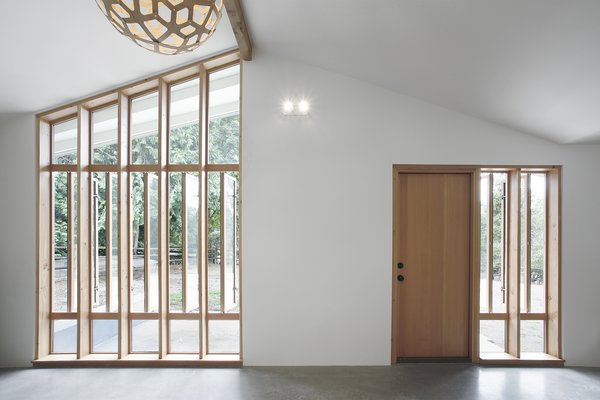 “The bank of full-height windows brings in tons of southern light, but it also gives the stable a strong street presence, and it ties into the stick-built window pattern already established at the entry to the main house,” Schaer says. The locally-sourced Douglas fir windows and doors were provided by Lindal Cedar Homes. Photo 6 of Horse Stable Studio modern home