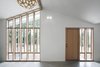 “The bank of full-height windows brings in tons of southern light, but it also gives the stable a strong street presence, and it ties into the stick-built window pattern already established at the entry to the main house,” Schaer says. The locally-sourced Douglas fir windows and doors were provided by Lindal Cedar Homes. Photo 6 of Horse Stable Studio modern home