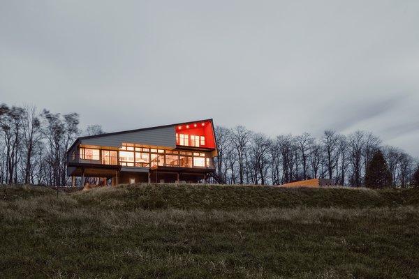 “For the structure, Mapos devised a hybrid system of concrete, steel, and Structural Insulated Panels (SIPs),” co-principal Caleb Mulvena says. “Each was strategically utilized to create a lightweight, rigid, and highly energy-efficient shell.” Fiber cement-board cladding and a steel standing-seam roof act as the structure’s envelope. Photo of Hudson Valley Dream Retreat modern home