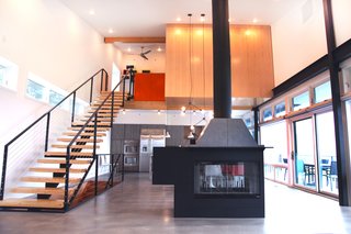 A Couple Builds Their Dream Retreat in the Hudson Valley - Photo 3 of 8 - The fireplace, which sits on buffed concrete flooring at the center of the ground floor, was custom-made by Mapos.