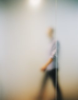 The frosted glass extends to the hallway, where a long corridor connects the bathroom to the master bedroom.