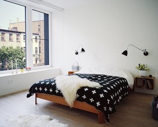 Set atop a BoConcept bed, a graphic blanket by Pia Wallén for HAY punctuates the master bedroom. The sconces are by Robert Dudley Best for Bestlite.