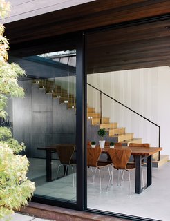 Wouldn't You Like to Have Your Own Private Concerts at Home? - Photo 4 of 10 - The new volume houses the dining area, which includes stairs to the bedrooms. The table is from Blake Avenue and the walnut chairs are from Room & Board. "You don't want bright colors to take away from that relationship between the interior and the exterior," Walker says.