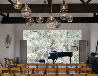 Wouldn't You Like to Have Your Own Private Concerts at Home? - Photo 8 of 10 - Located in the renovated barn, the living room can be transformed into a performance space that seats 80. The art piece is from South Africa. Accompanying the Steinway piano is a sideboard from Restoration Hardware; the pendants are from Cisco Home.