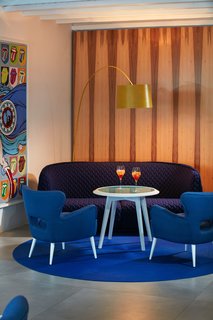 To welcome eager travelers, the reception area is filled with various seating areas and brimming with contemporary furnishings that divert drastically from the neighboring classic Greek architecture. 