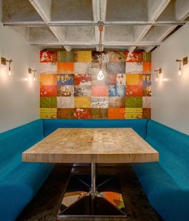 This Retro Apartment Is Finally the Good Kind of Funky - Photo 3 of 7 - The studio created a breakfast nook with a colorful mural in the heart of the home. The metal sconces are custom. 